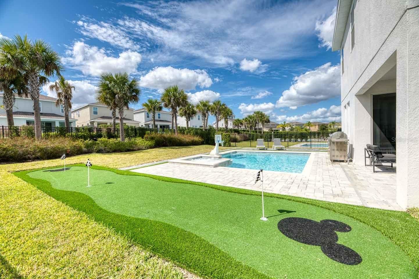 backyard with mickey putting green and pool